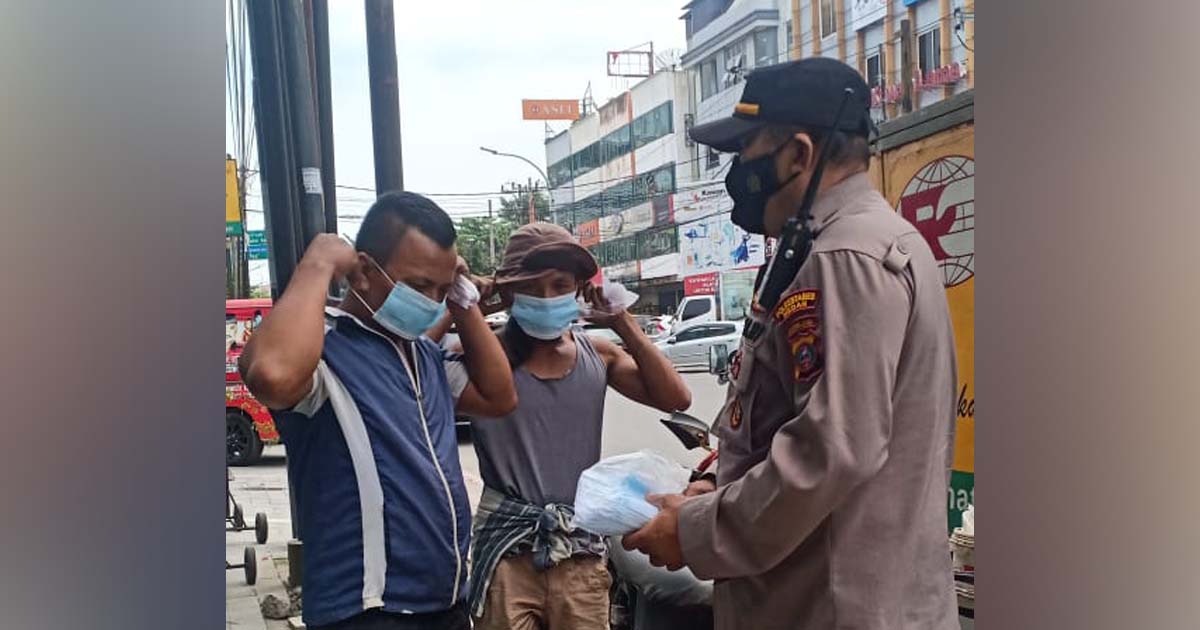 Kanit Binmas Polsek Medan Baru Bagikan Masker pada Warga Pengguna Jalan